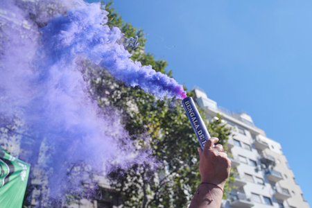 Buenos Aires, Argentina; March 8, 2024: hand raising a purple smoke flare in the air during the 8M...