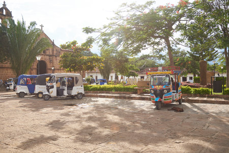Guane, Santander, Colombia; Nov 26, 2022: main square, colorful picturesque motorcycle cabs awaiting...