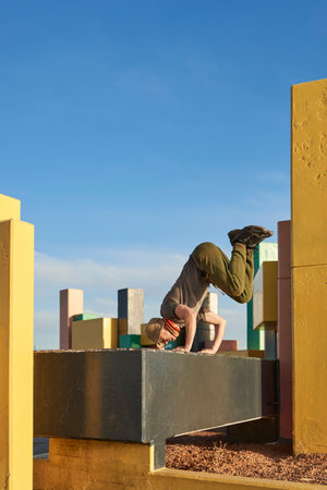 Hispanic man standing on his hands, enjoying moving the body freely, practicing parkour, an athletic urban sport popular among young people.の写真素材