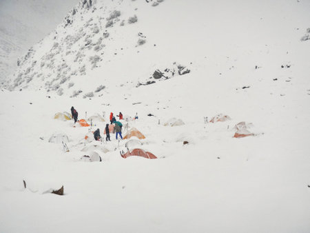 Mountaineering during wintertime: group of people in a wintry Andean scenery, a snowy mountain...