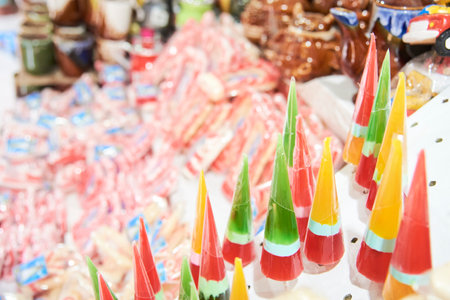 Sale of traditional sweets in Paramo, Santander, Colombia. Composition with selective focus in the foreground: conical lollipops with vivid colors.の写真素材