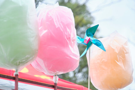 Childhood fun at a fair: sweet cotton candy in different colors and a simple toy, a pinwheel.の写真素材