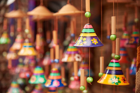 Sale of ceramic handicrafts in Raquira, Boyaca, Colombia: colorful hanging bell ornaments in a composition with copy space and selective focus.の写真素材