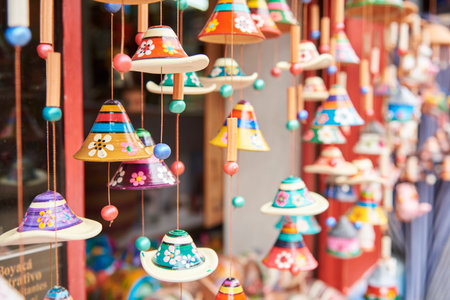 Sale of ceramic handicrafts in Raquira, Boyaca, Colombia: colorful hanging bell ornaments in a composition with copy space and selective focus.の写真素材