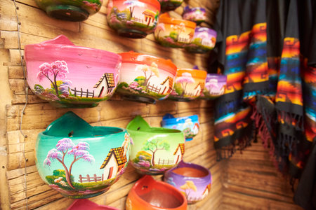 Sale of handmade ceramic pots, painted with colorful traditional scenes, in Raquira, Colombia.の写真素材