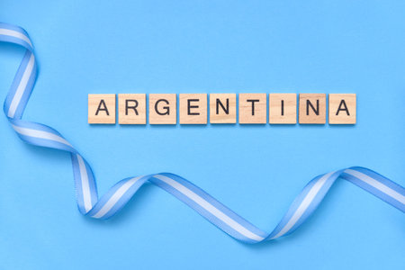 The word Argentina surrounded by a ribbon with the national flag on a light blue background.