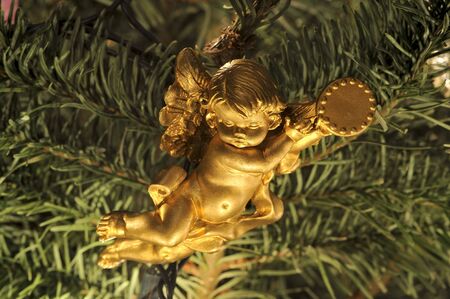 Hanging angel (cherub) ornament in a Christmas tree. Macro.の写真素材