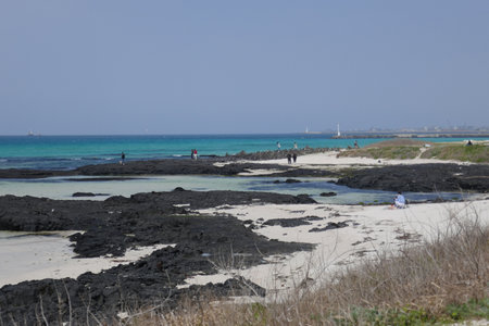 Geumneung Beach, Jeju Island, South Korea - April 17, 2018 : People enjoying the turquoise blue sea and white sand.のeditorial素材