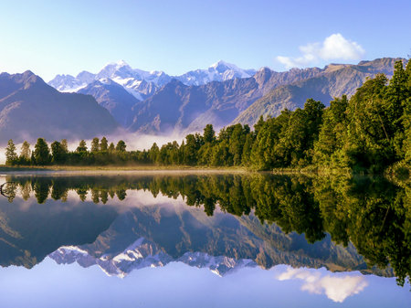 Mirror lake, Lake Matheson, with mountains, Mount Cook / Aoraki, in the background seen from jetty viewpoint in March at dawnの写真素材