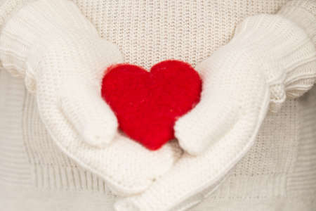 Red Valentines Day heart in hands with mittensの写真素材