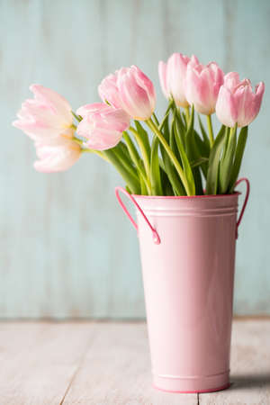 Pink and white pastel Tulips in a pink bucket vaseの写真素材