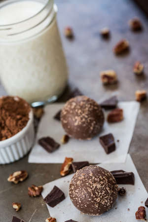 Chocolate truffles with cocoa and cream and surrounded by chocolate and pecansの写真素材