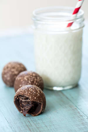 Chocolate truffles with milk in a glass jar with straw