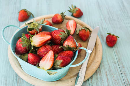Strawberries on a wood cutting board with knifeの写真素材