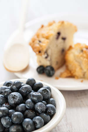 Bowl of blueberries with blueberry muffin breakfast with wooden spoonの写真素材