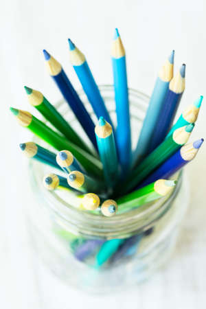 Blue and green colored pencils from above in a glass jarの写真素材