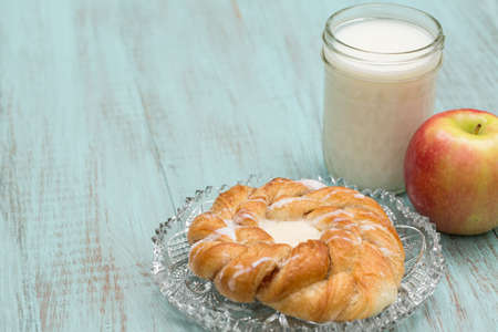 Danish bakery pastry with milk and fresh apple on blue wood tableの写真素材