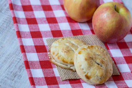 Autumn apple hand pies on red checkered napkinの写真素材