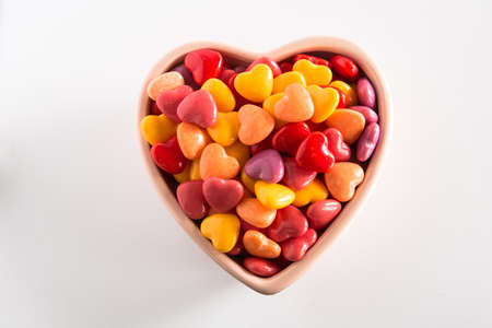 Colorful Valentines Day candy in ceramic heart shaped bowlの写真素材