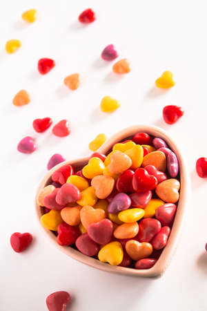 Colorful heart shaped Valentines Day love candy in ceramic bowlの写真素材