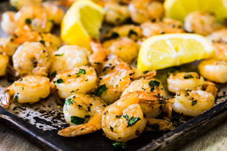 Shrimp seafood supper on metal sheet pan with lemon wedgesの写真素材