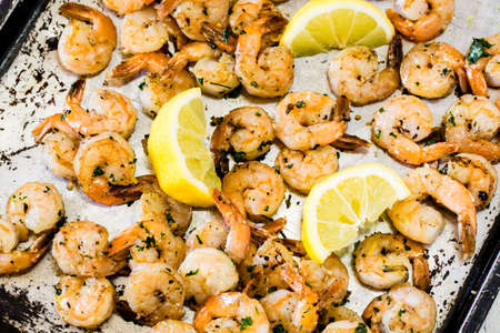 Sauteed shrimp seafood dinner on metal sheet pan with lemon wedgesの写真素材