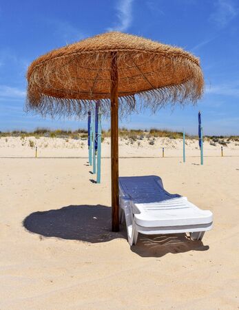 Straw Umbrella and Chairs Backgroundの写真素材
