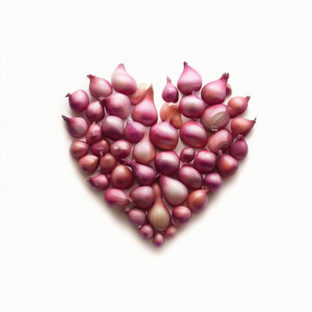 Shallot onions arranged in the shape of a heart on white backgroundの素材