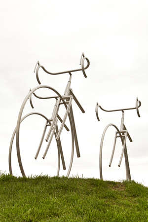 Steel sculpture of bikes on grass.の写真素材