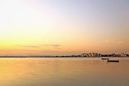 The city and the river with two small boats at sunset の写真素材