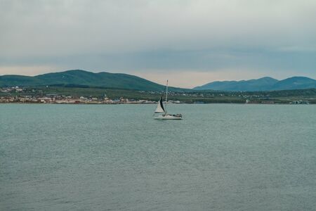 Russia Krasnodar region Gelendzhik. Sailing boat sailing on the Black Sea. View of the Caucasus Mountainsの写真素材