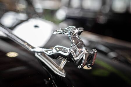 MOSCOW, RUSSIA - March 10, 2018: Close-up of shiny chrome plated deer on the hood of the retro car GAZ M21 Volga, vintage car, selectiv focus. Retro cars festivalのeditorial素材
