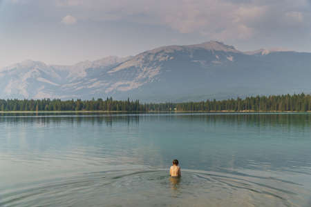 Child in Cold Glacier Water in Lake in Jasper National Park, Jasper, Albertaの写真素材