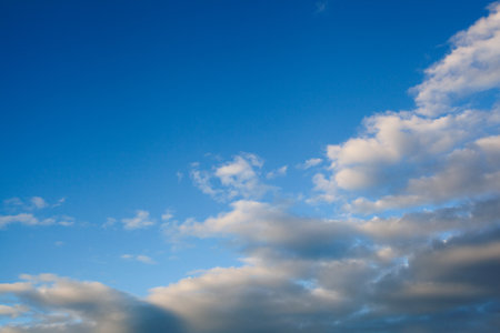 A sunset emerges up through the soft, white clouds.