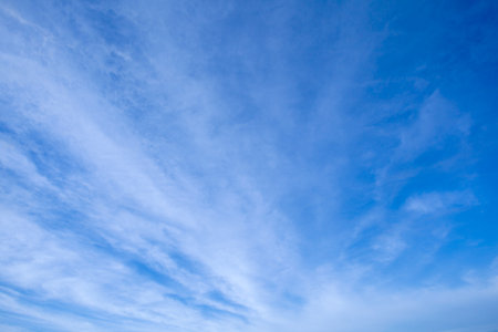A radial white cloud formation streaks across a blue sky.の写真素材