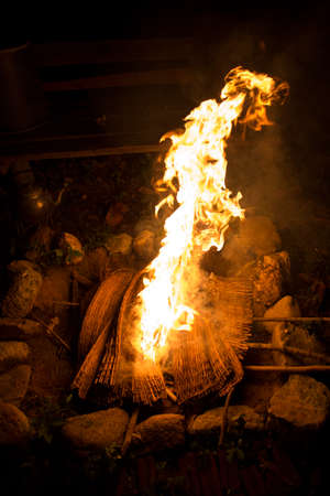 close up of the bonfire with burning bamboo mat soft focus dark background