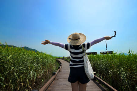 A woman who takes a walking between green reeds