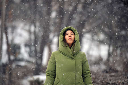 A woman who is looking at snow in the forestの写真素材