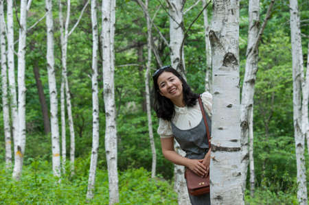 Smiling woman in the birch forest