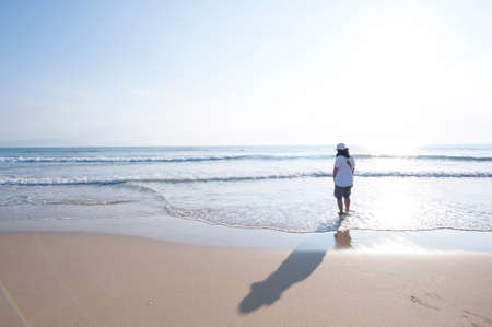 A woman walking on the beachの写真素材