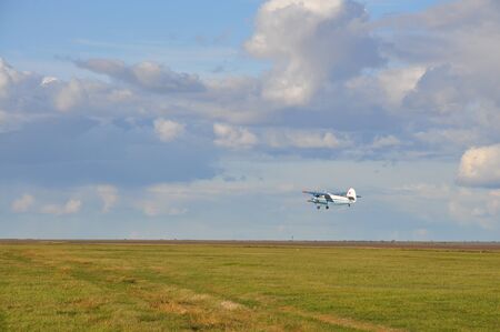 Small airplane flying above the field