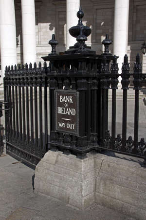 Entrance of Bank of Ireland in Dublin with the way out sign and black iron barsの写真素材