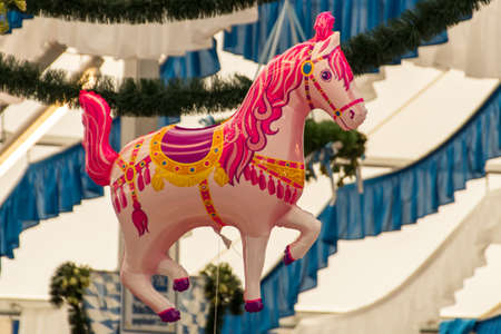 Pink horse balloon in a beer tent with the decorated roof of the beer tent in the backgroundの写真素材