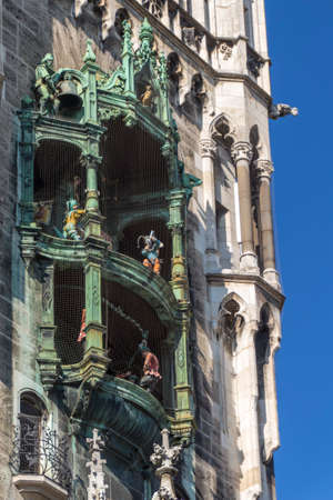 The Glockenspiel in the tower of the new city hall with different figures is a famous tourist attraction in Munichの写真素材
