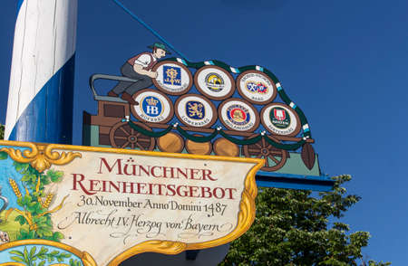 Maypole at Viktualienmarkt with a colored figure and the signs of the Munich beers to remind of the German purity lawのeditorial素材