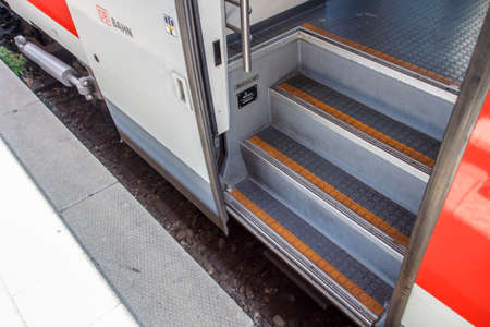 Train with an open door waiting at the station platform for departure