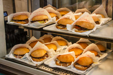 Inside the Ochsenbraterei beer tent at Oktoberfest with a sales stall offering the famous oxen rollのeditorial素材