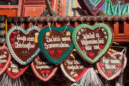 Gingerbread hearts labeled with "Greeting from Munich", "You are my sunshine" and "You are awesome to me" are sold on the Theresienwiese during Oktoberfestの写真素材
