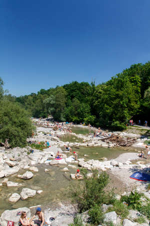 The Isar river in Munich with many unidentified people on a sunny day taking a sunbathのeditorial素材