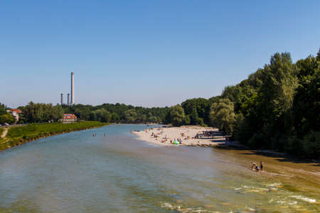 The Isar river in Munich with many unidentified people on a sunny day taking a sunbathの写真素材